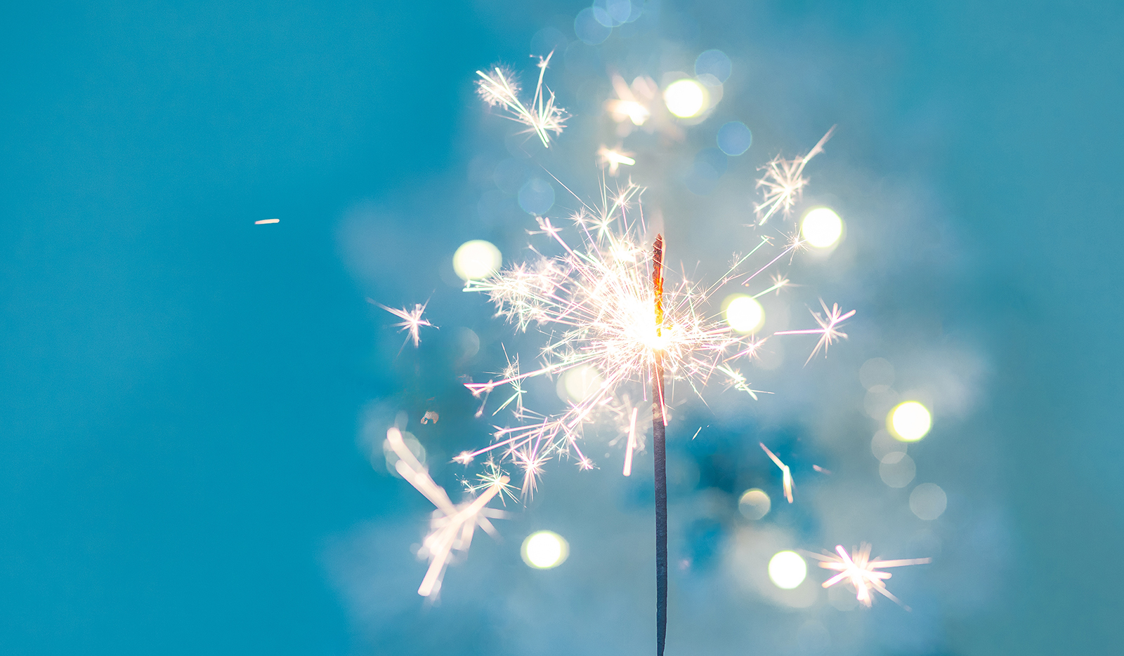 Beautiful sparkles from sparklers on the background of New Year's bokeh, xmas. Christmas mood, festive background. banner.